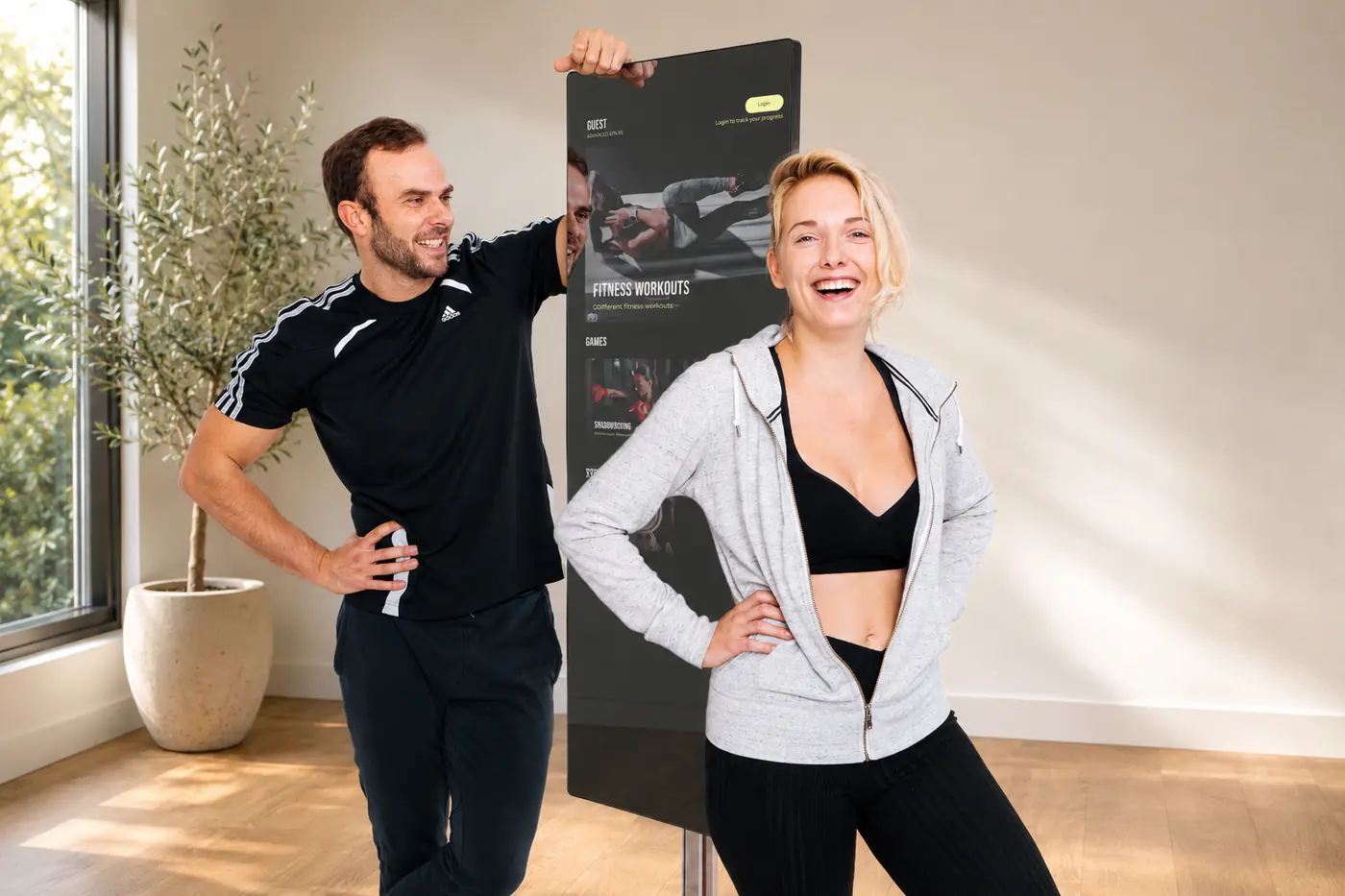 Two people beside a Fittar Compact Smart Mirror in a bright living space